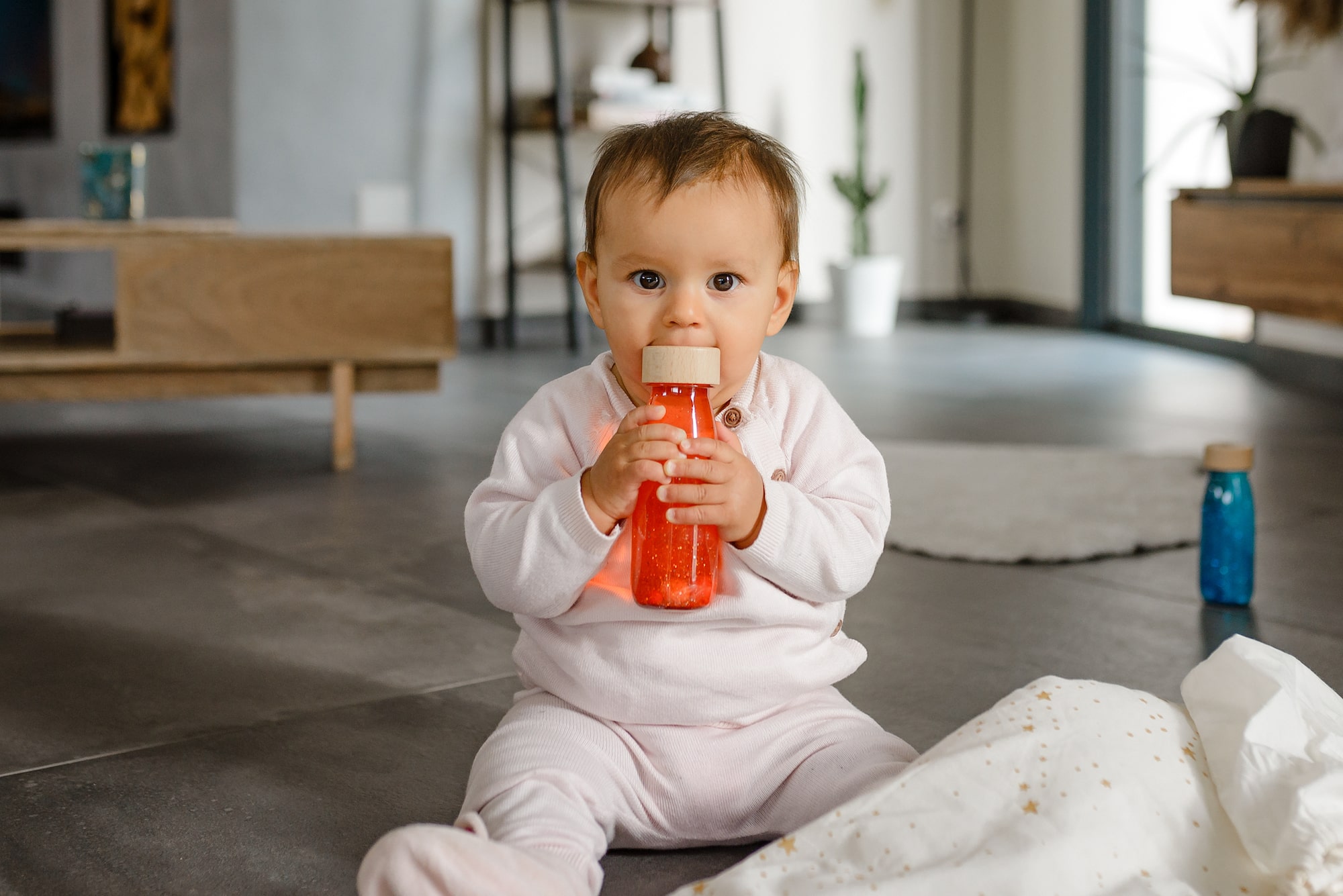Eclat d'Eveil box jeu évolutives pour enfants - bebe manipule une bouteille sensorielle orange